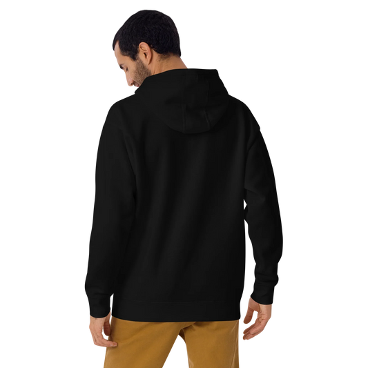 Mann trägt unisex schwarzes Premium Hoodie von hinten, kombiniert mit beige Hose, urbaner Casual-Look